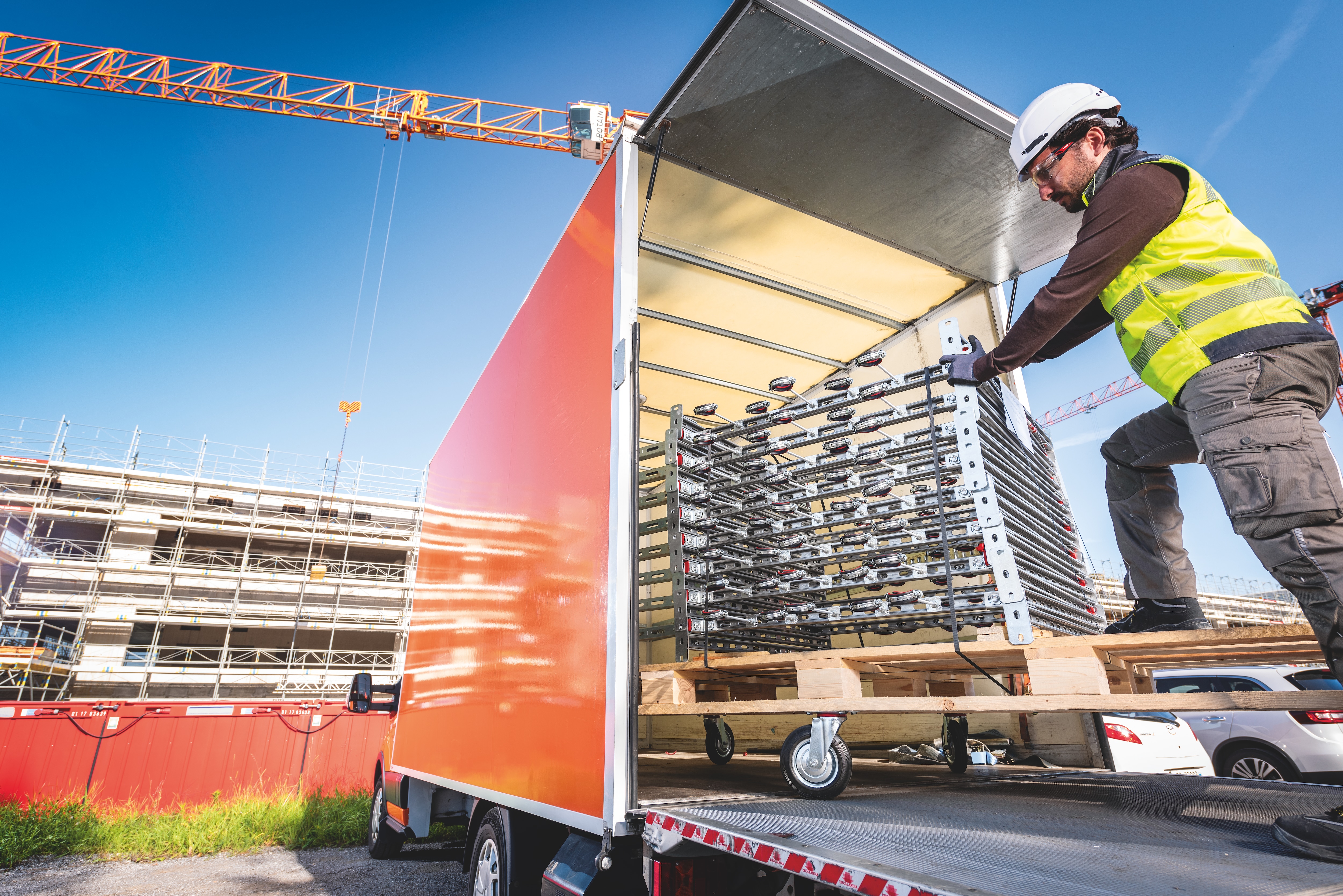 Worker unloading prefabricated modular support modules from a truck