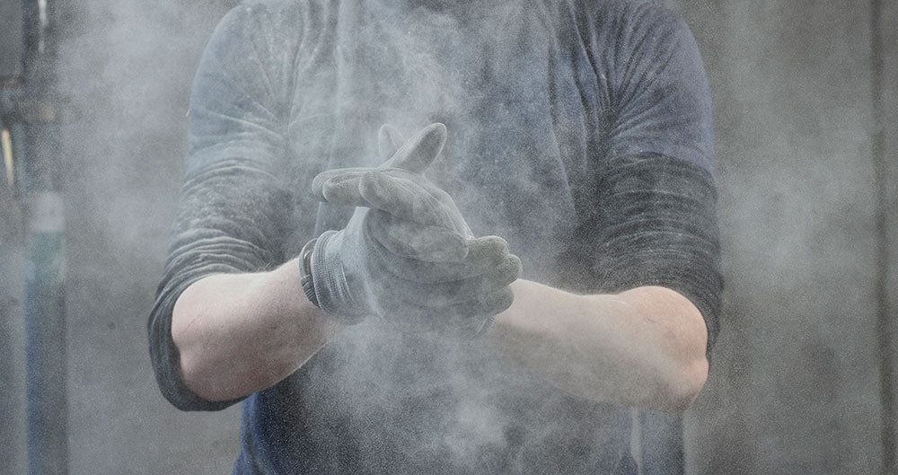 person expelling dust from gloves