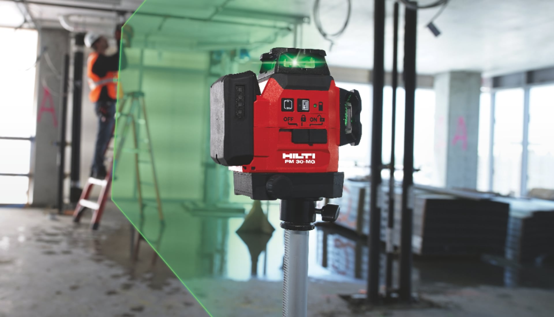 A laser scanning a building site with a man working on a ladder in the background