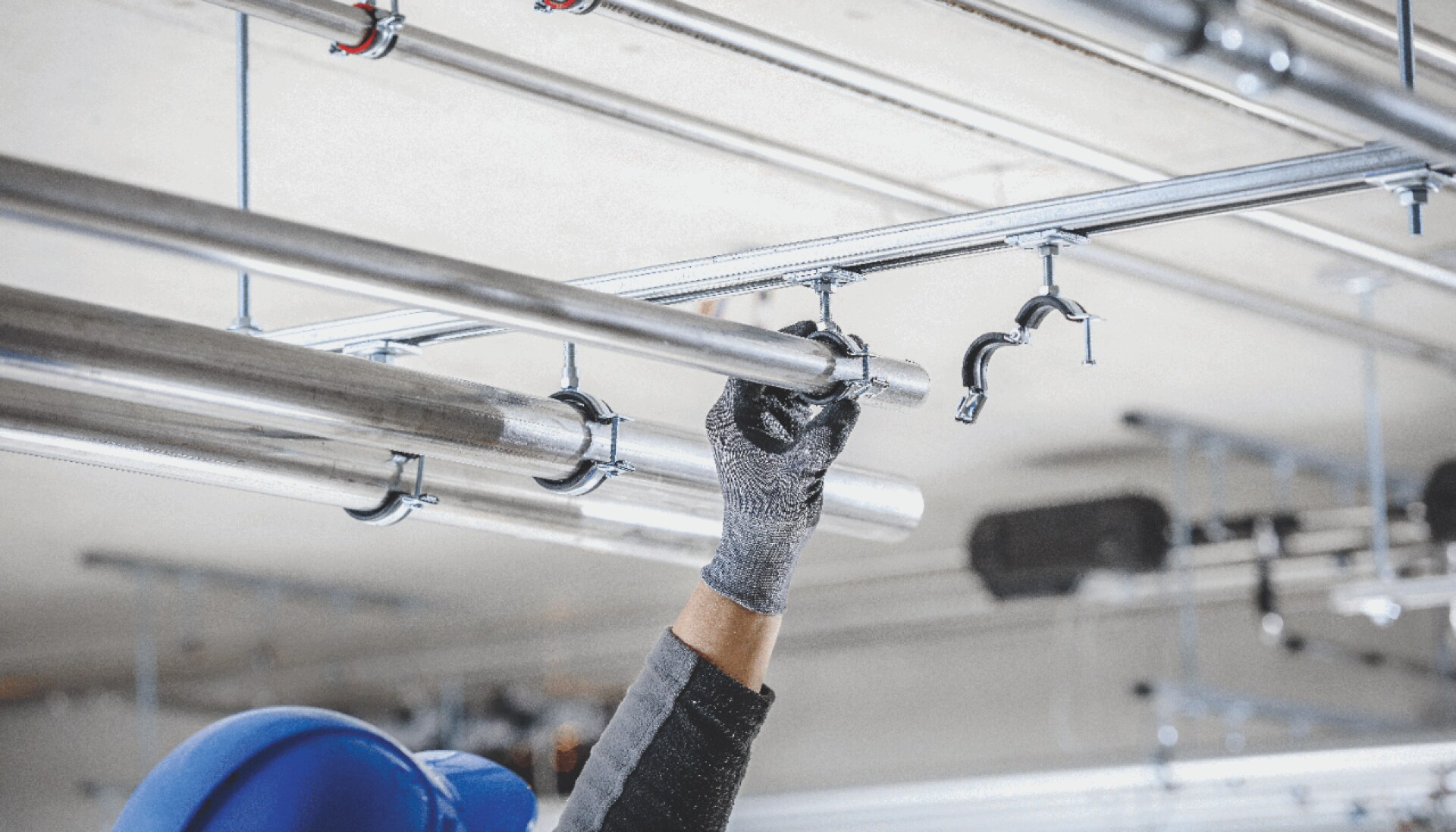 A metal rail being fitted to a ceiling