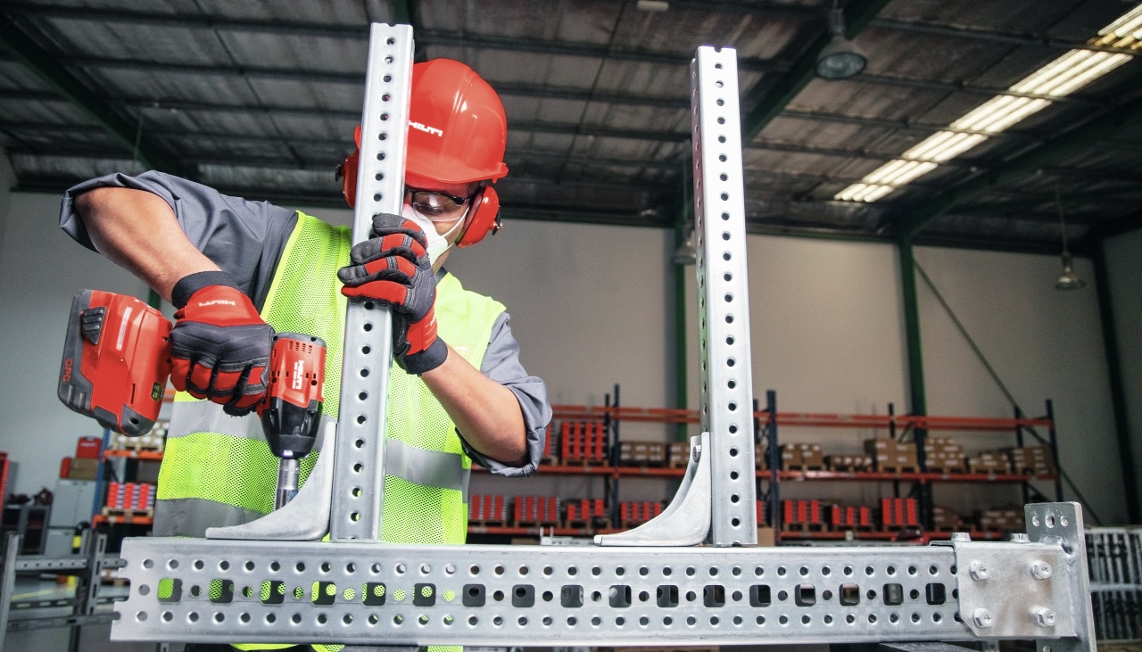 man using Hilti drill driver to connect metal bars