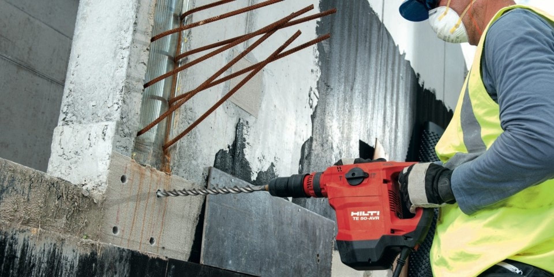 A worker drilling into a wall with a Hilti tool