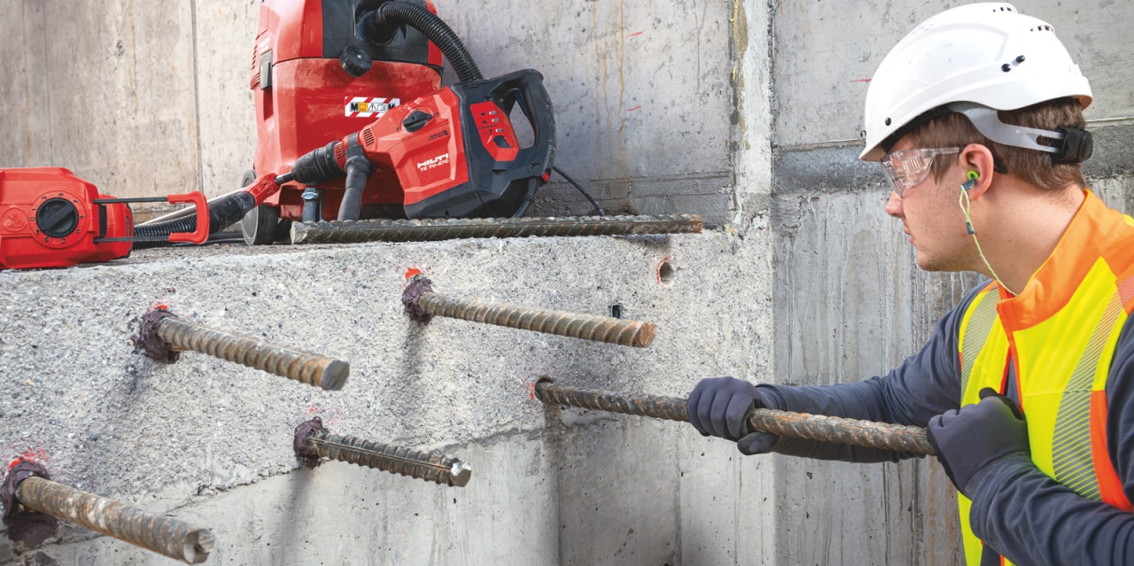 man connecting concrete bars into a concrete wall