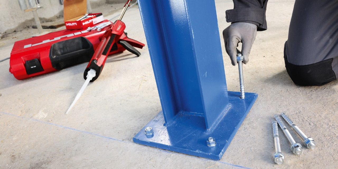 Man connecting steel column to concrete floor
