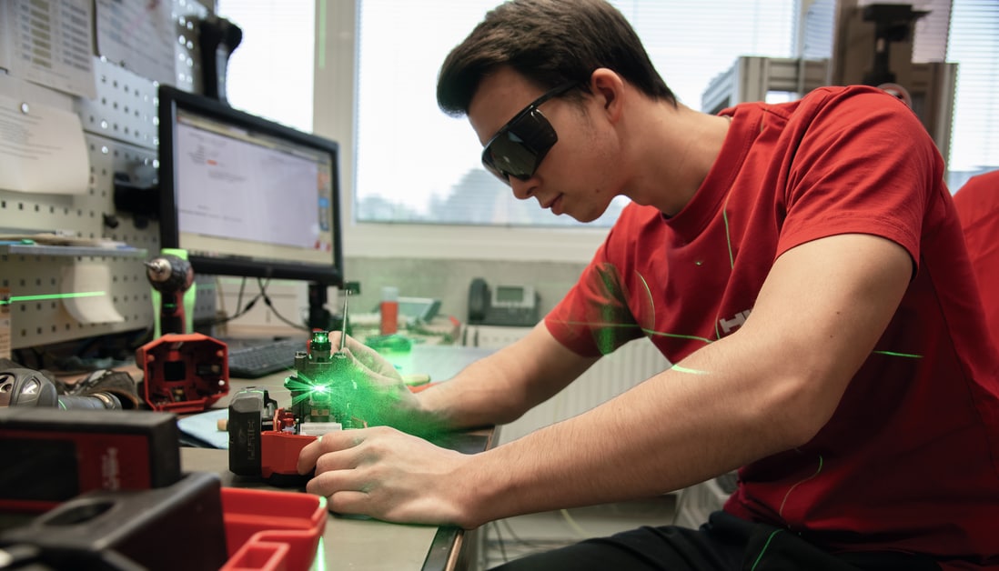 working in red tshirt calibrating a laser