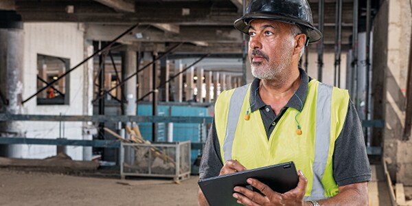 a person in a high vis vest making notes on a pad