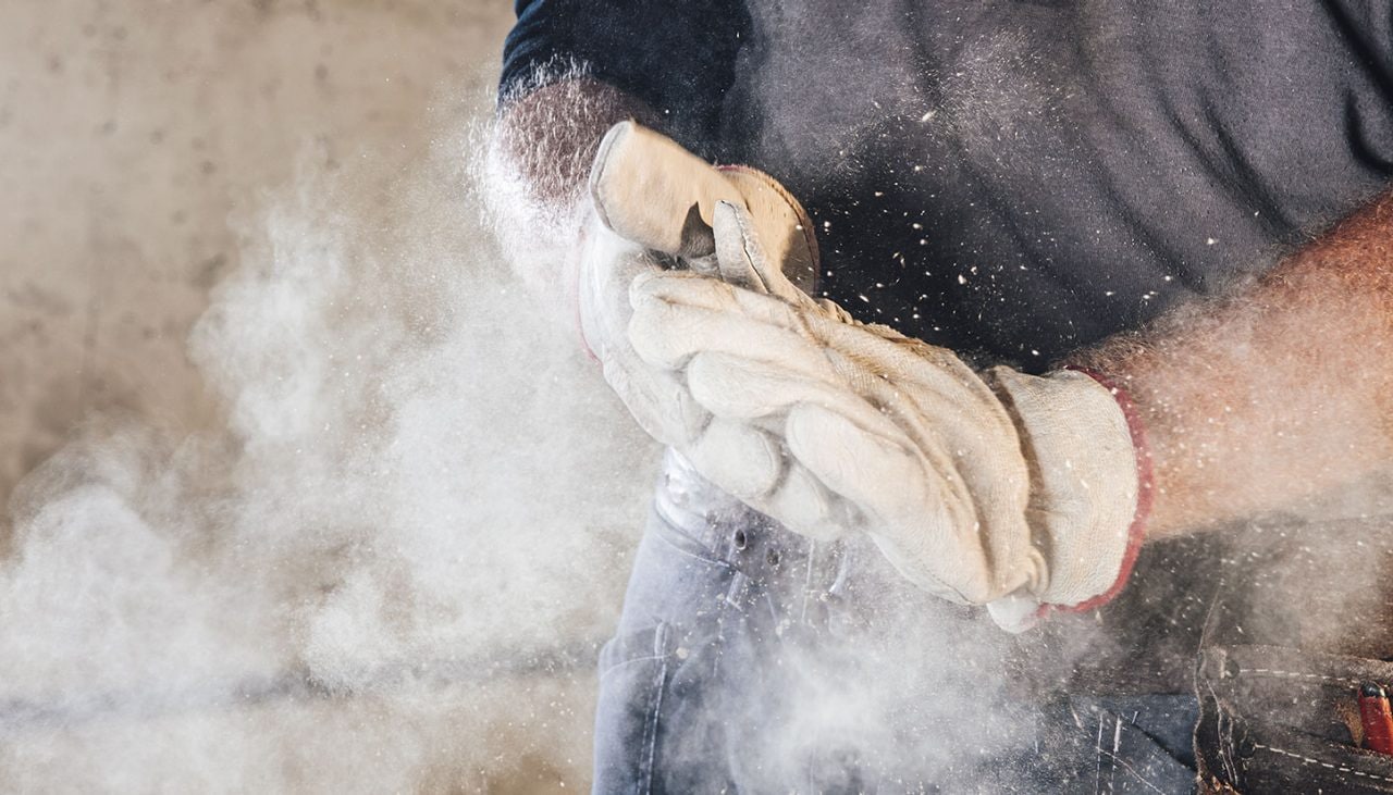dust expelling from mans work gloves