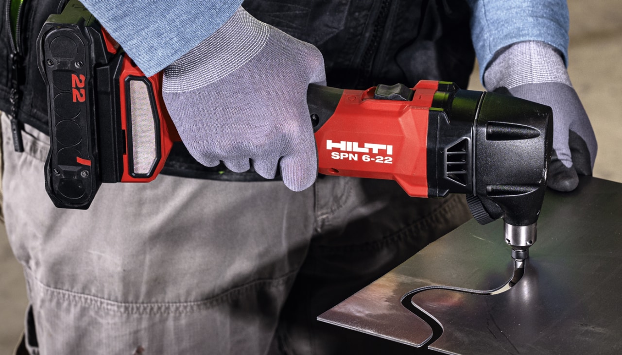 man using cordless nibbler on metal