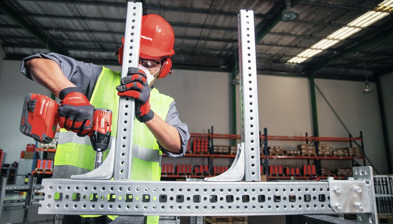 person using a red hilti tool to prepare channel