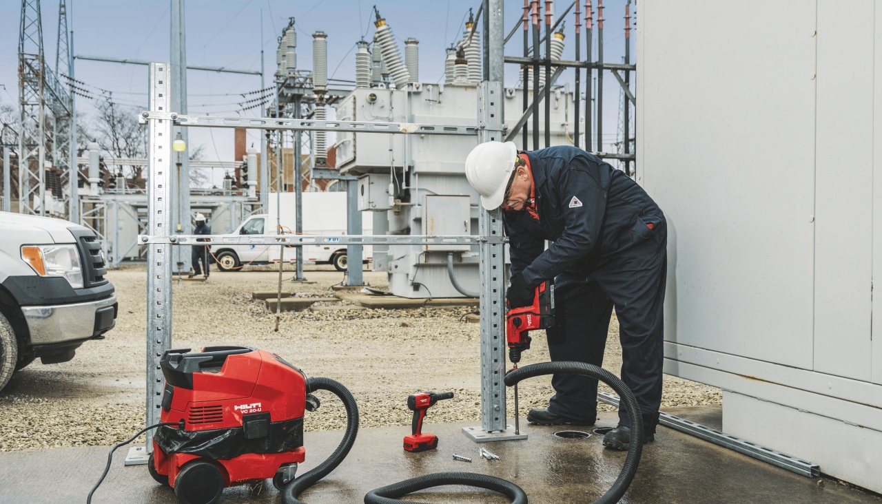 man Fastening equipment to concrete​ using Hilti tools