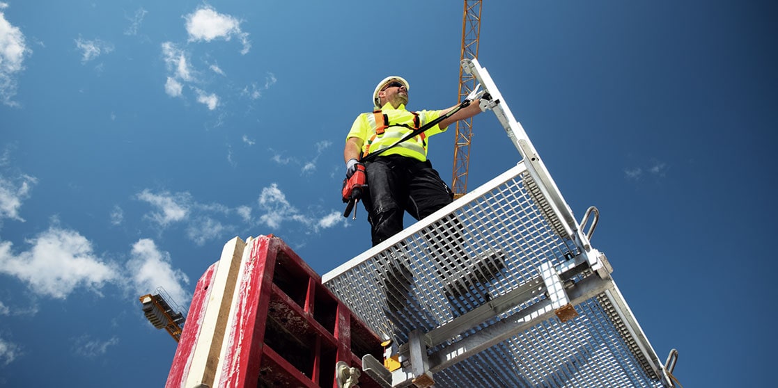 Construction worker on a elevated platform in the sun