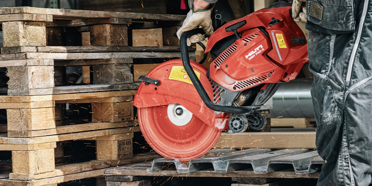 person using a red Hilti cut off saw