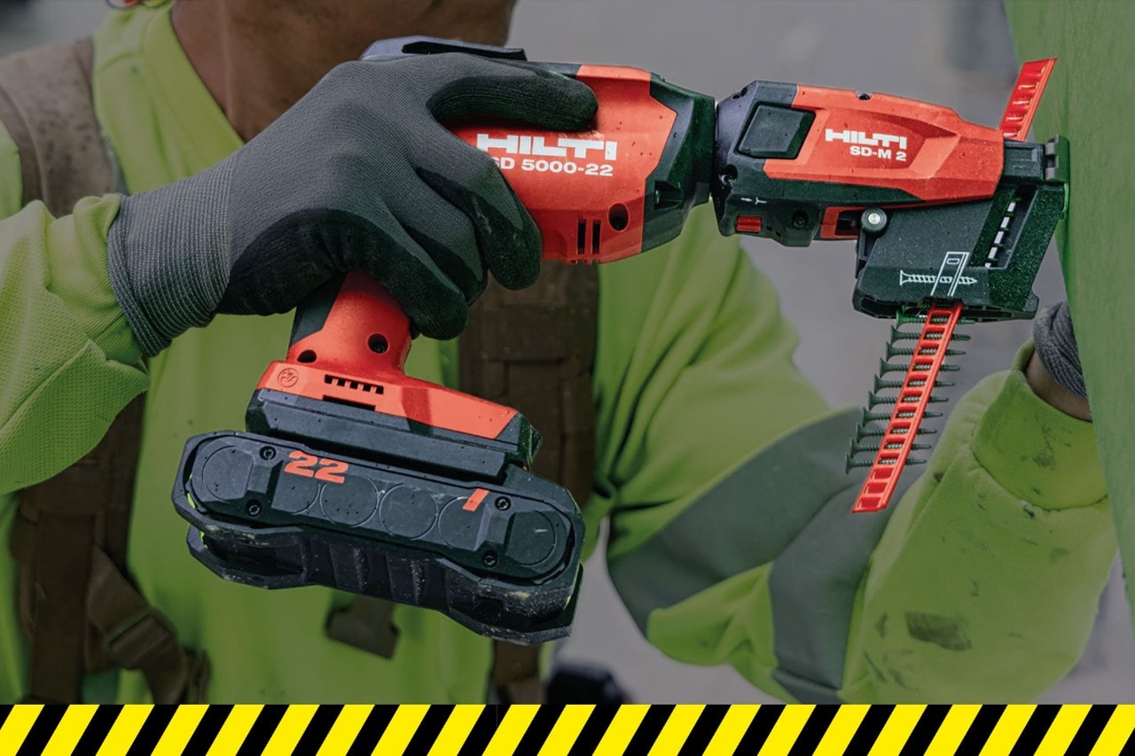person using a red Hilti electric screw fastener
