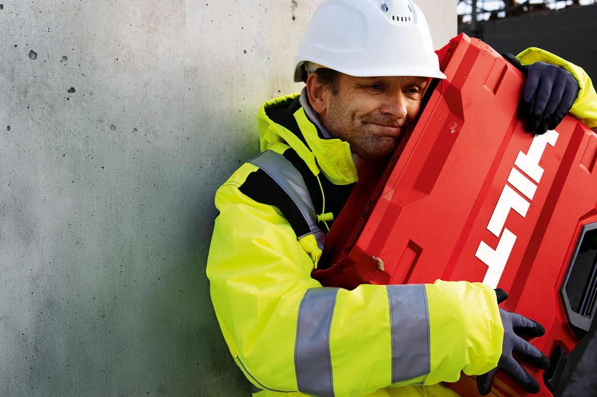 man hugging a red Hilti tool case