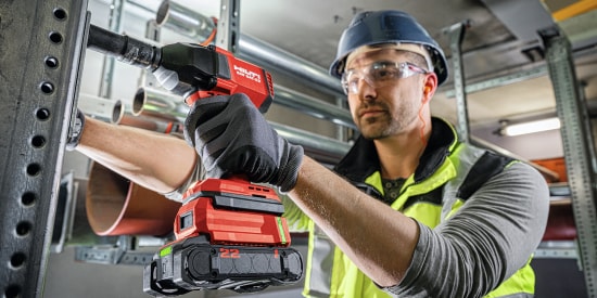 man using impact wrench on metal bar