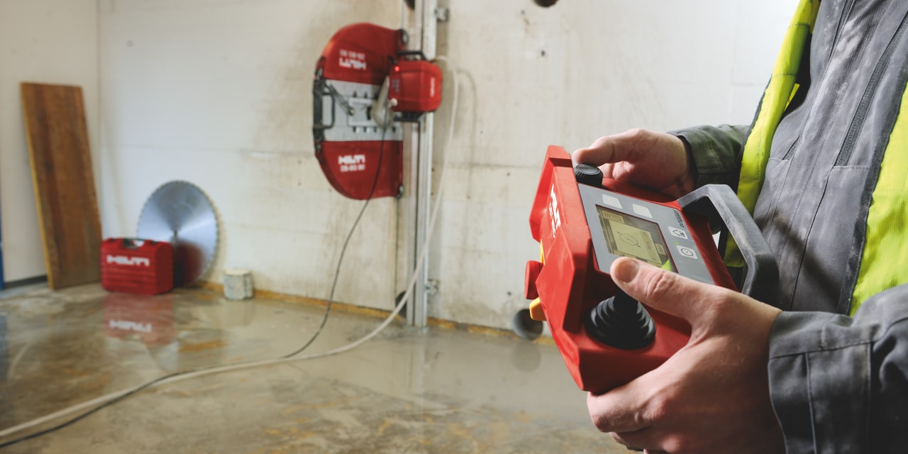 A worker using a remote control to operate a Hilti diamond wall saw