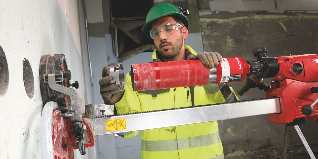A worker operating a Hilti diamond core drill