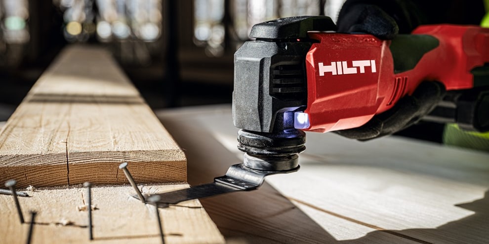 A Hilti multi tool removing nails from a plank of wood