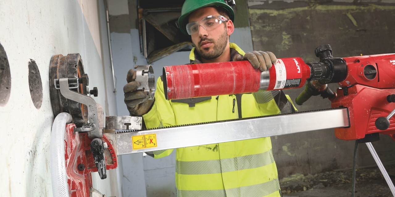 A worker operating a Hilti diamond core drill
