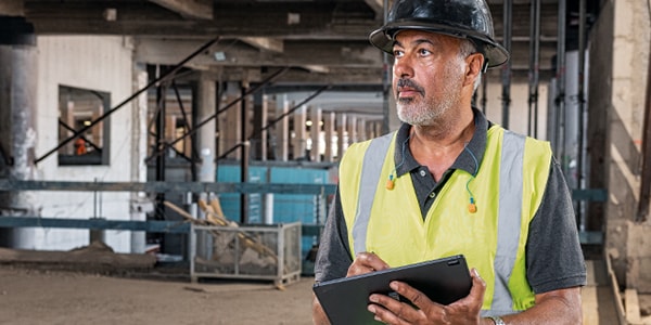 a person in a high vis vest making notes on a pad