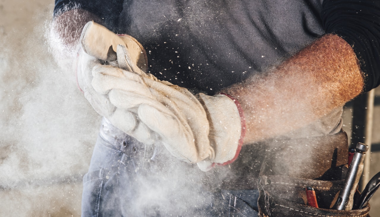 a person wearing gloves rubbing their hands together producing dust