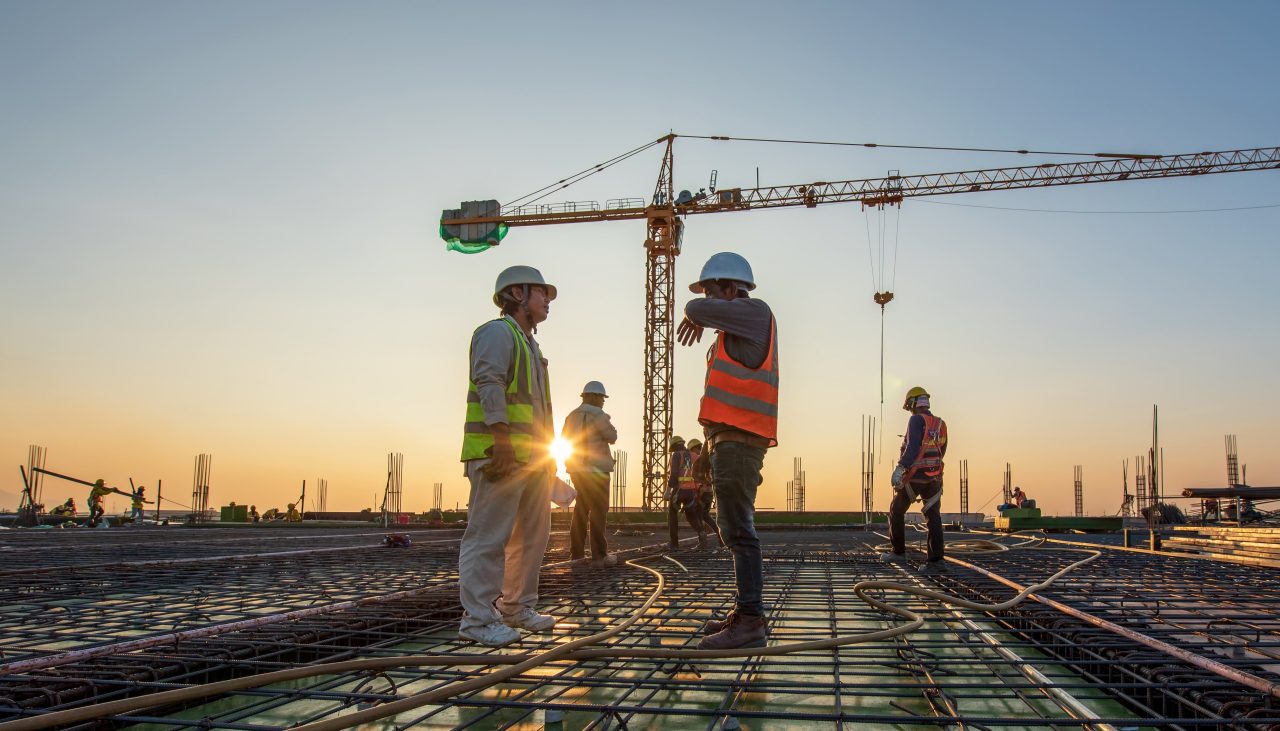 people in Hi Vis vests with a crane in the background